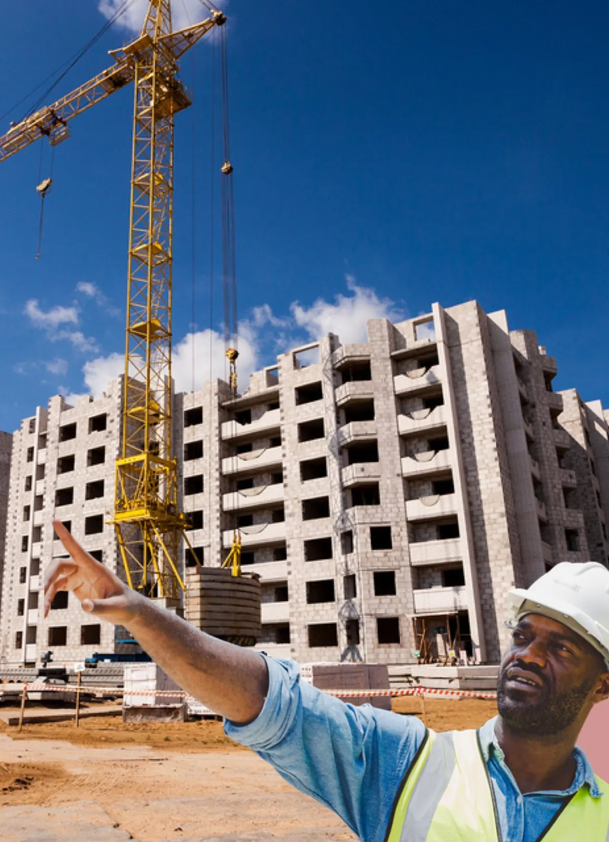Immeuble en construction avec grues sous un ciel bleu, chef de chantier en casque blanc